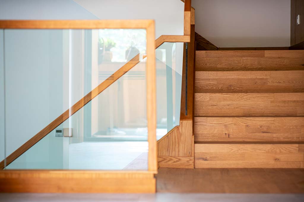 Treppen aus Holz in warmem Hellbraun mit passendem Gelände mit Glas Hocra Tischlerei und Objekteinrichtung aus Herne